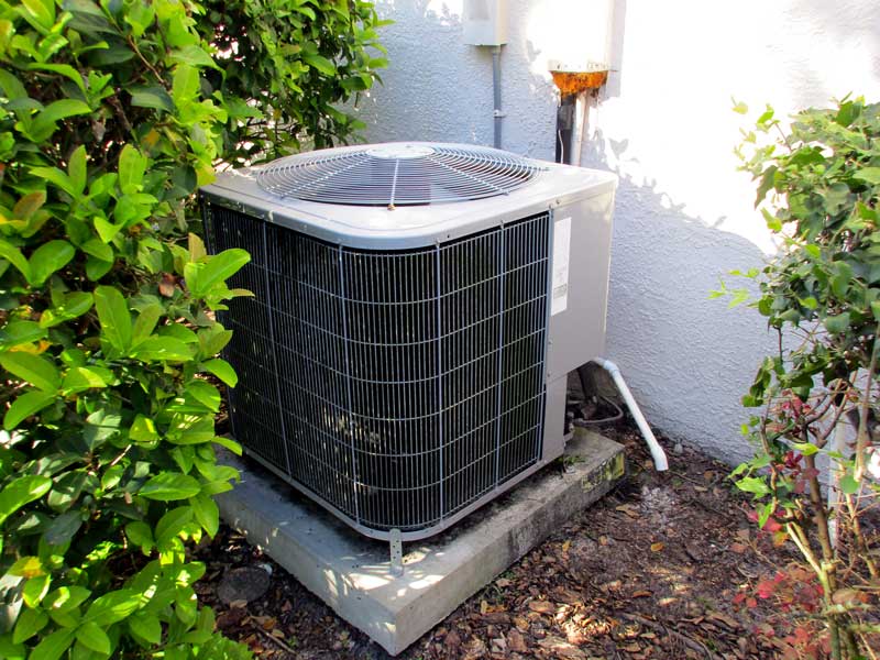 AC unit sitting aside a house.